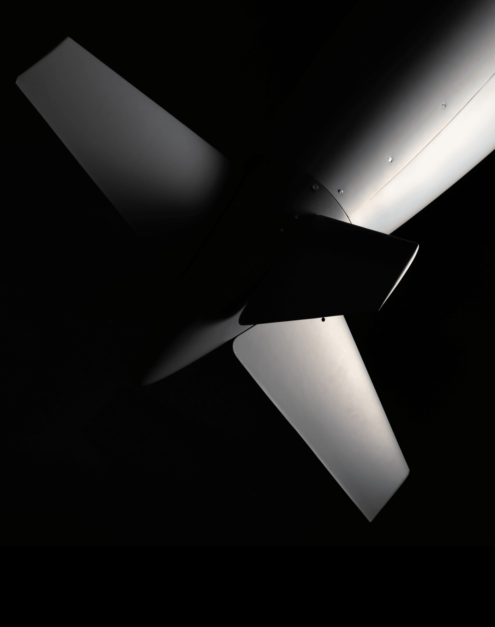 The cruciform tail fins of the Covenant airframe seen from below against black.